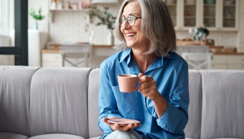 Dentures patient in Danville smiling with tea